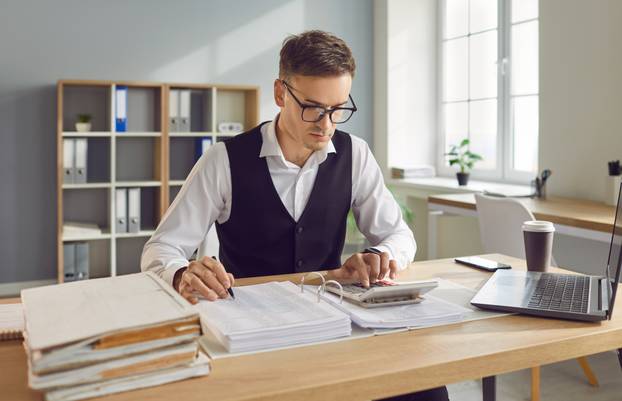 Young,Confident,Business,Man,Accountant,Working,With,Financial,Documents,Sitting