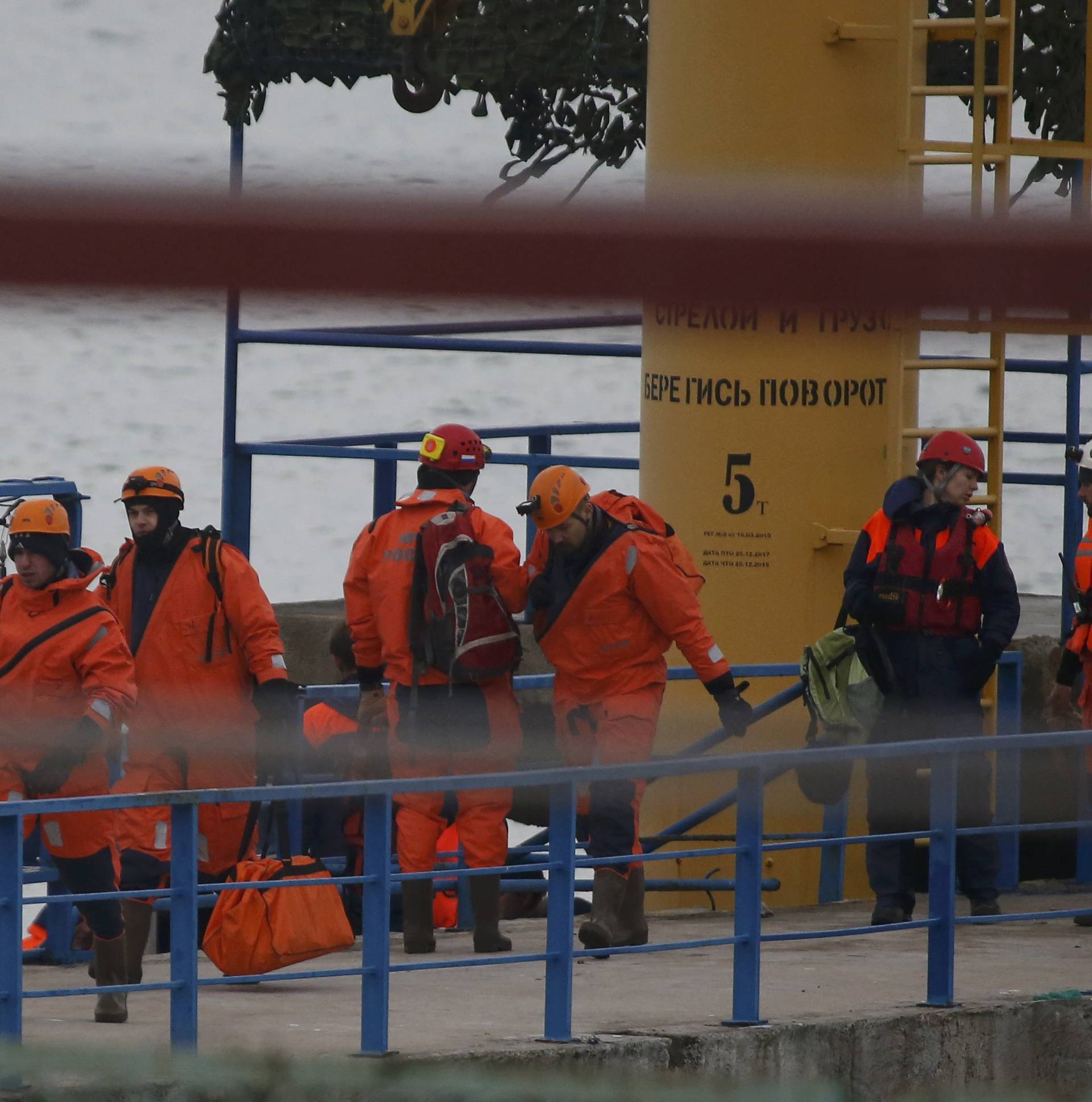 Russian Emergencies Ministry members walk on pier near crash site of Russian military Tu-154 plane in Black Sea in Sochi suburb of Khosta