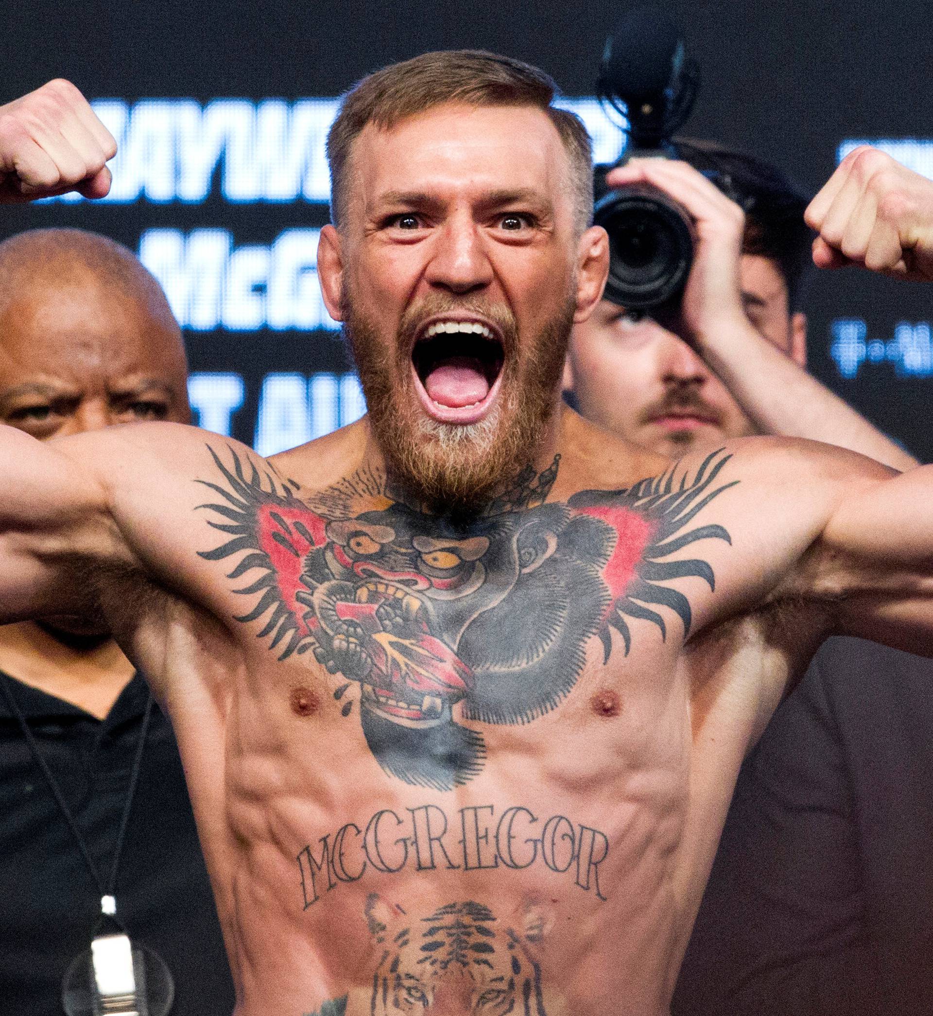 UFC lightweight champion Conor McGregor of Ireland poses on the scale during his official weigh-in at T-Mobile Arena in Las Vegas