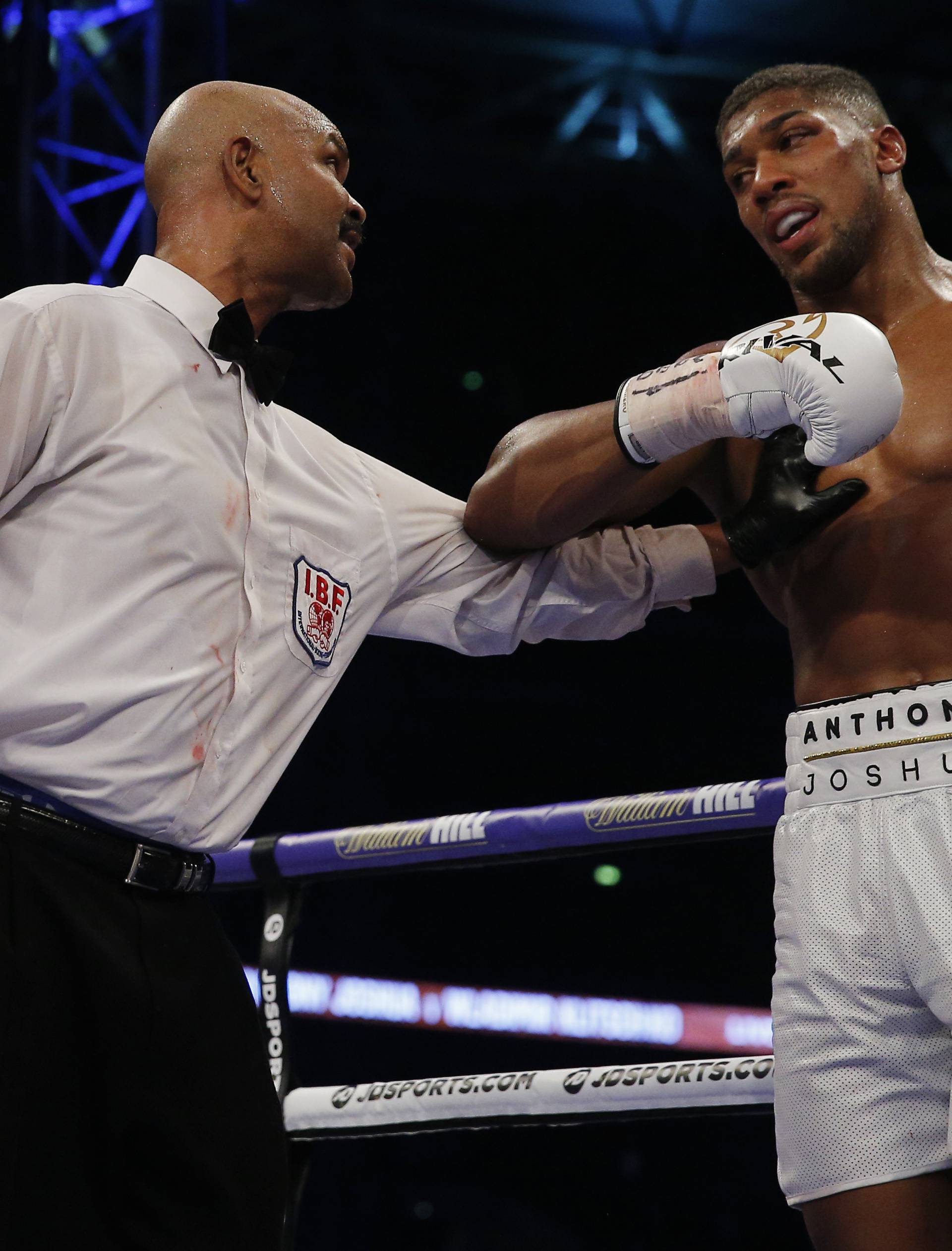 Anthony Joshua is spoken to by the referee