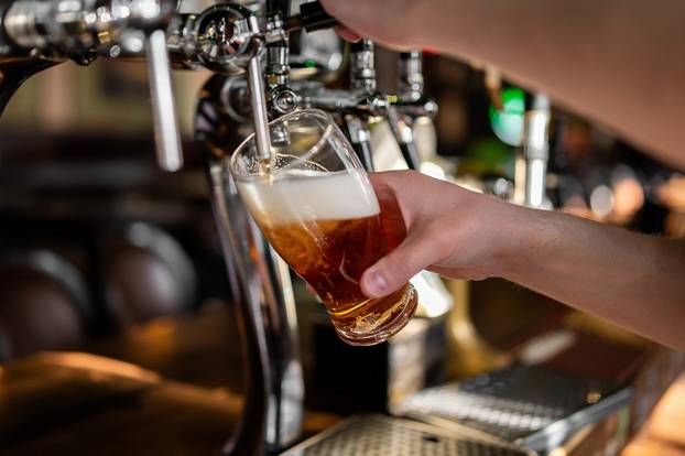 Close-up,Of,A,Bartender's,Hand,Pouring,A,Fresh,Amber,Draught