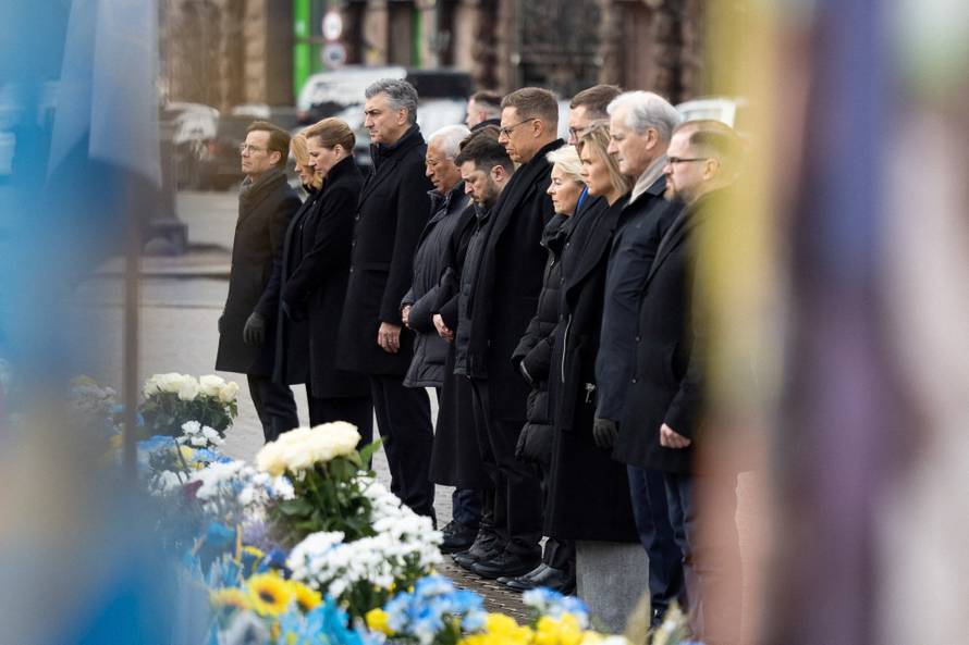 Ukraine's President Zelenskiy his wife Olena and foreign leader visit a makeshift memorial to fallen Ukrainian defenders at the Independent Square on the fourth anniversary of Russia's full-scale invasion, in Kyiv