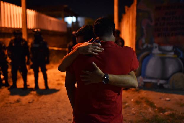 People react at a crime scene where unidentified assailants opened fire at a bar in Minatitlan