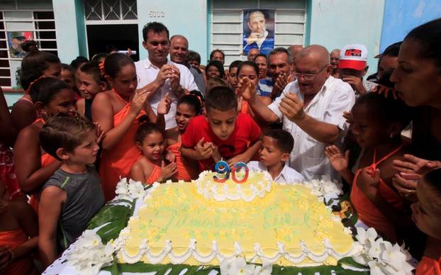 Ten-year-old Marlon Mendez blows out candles on birthday cake during an event organized by Marlon to celebrate the 90th birthday of Cuban former president Fidel Castro, in San Antonio de los Banos