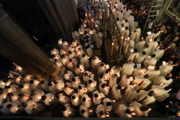Worshippers take part in a procession during the Catholic Washing of the Feet ceremony on Easter Holy Week in the Church of the Holy Sepulchre in Jerusalem