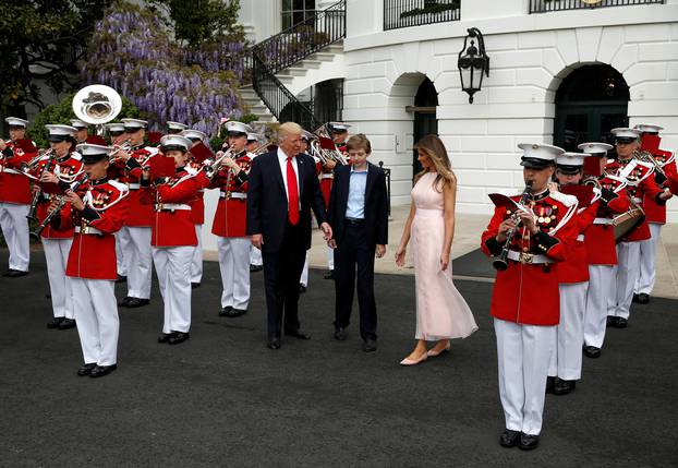 U.S. President Donald Trump, U.S. first lady Melania Trump and the their son Barron listen as a military band plays during the 139th annual White House Easter Egg Roll on the South Lawn of the White House in Washington