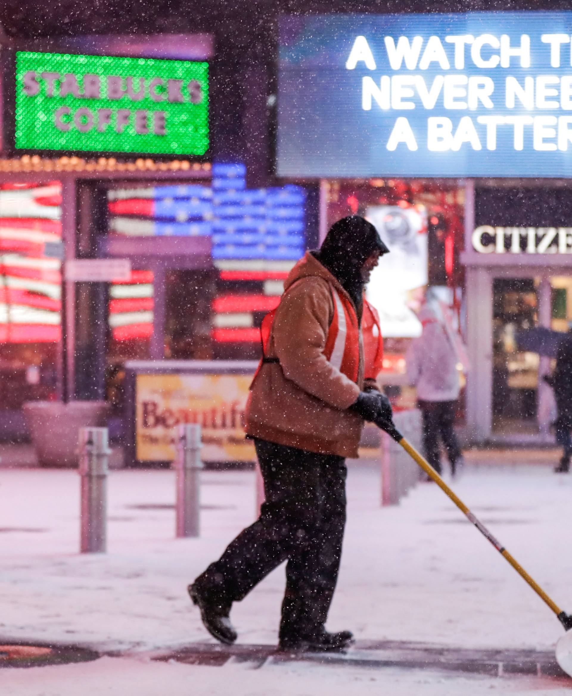 A worker removes snow during a snowstorm in Times Square in Manhattan