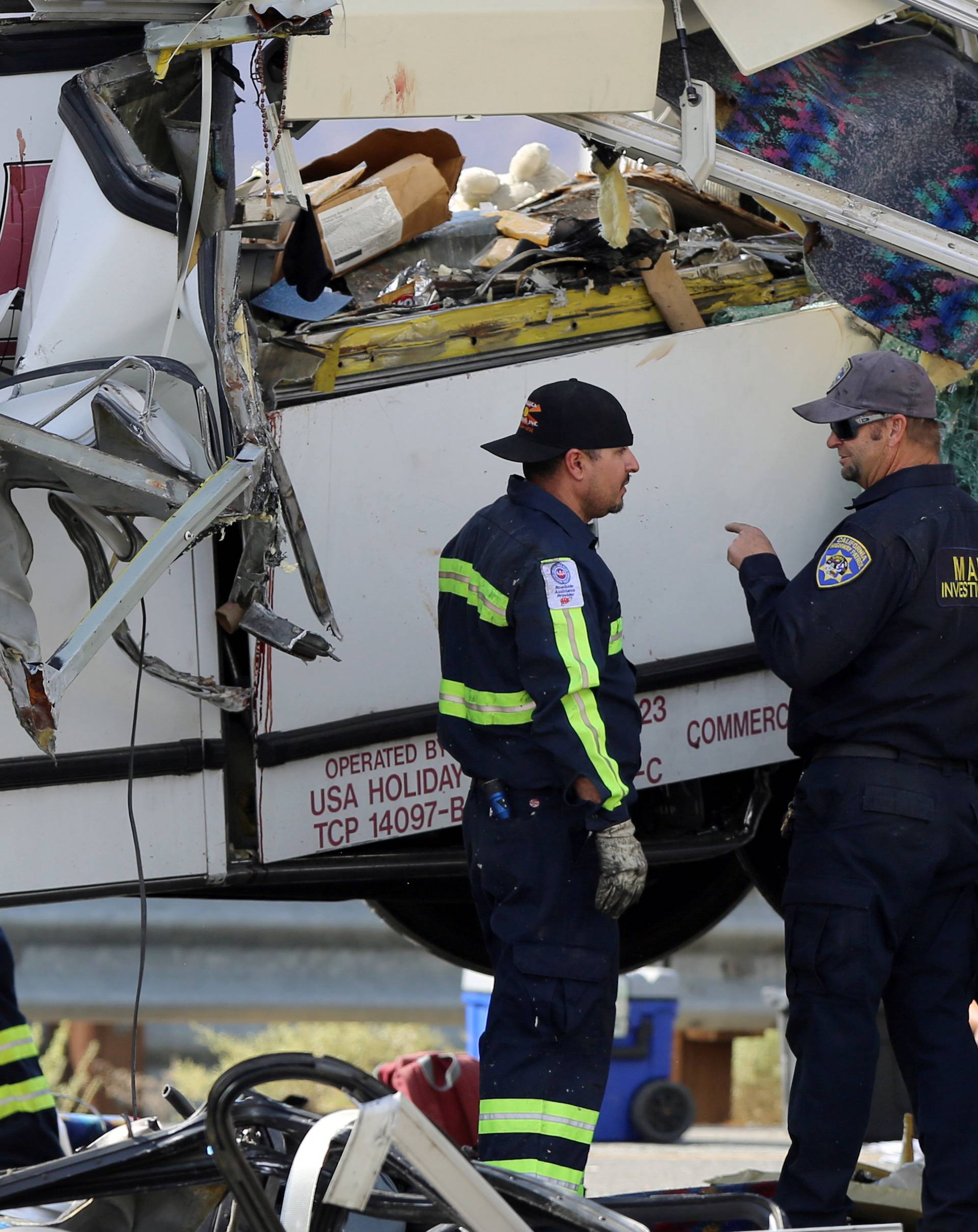 Investigators speak to each other at the scene of a mass casualty bus crash on the westbound Interstate 10 freeway near Palm Springs, California