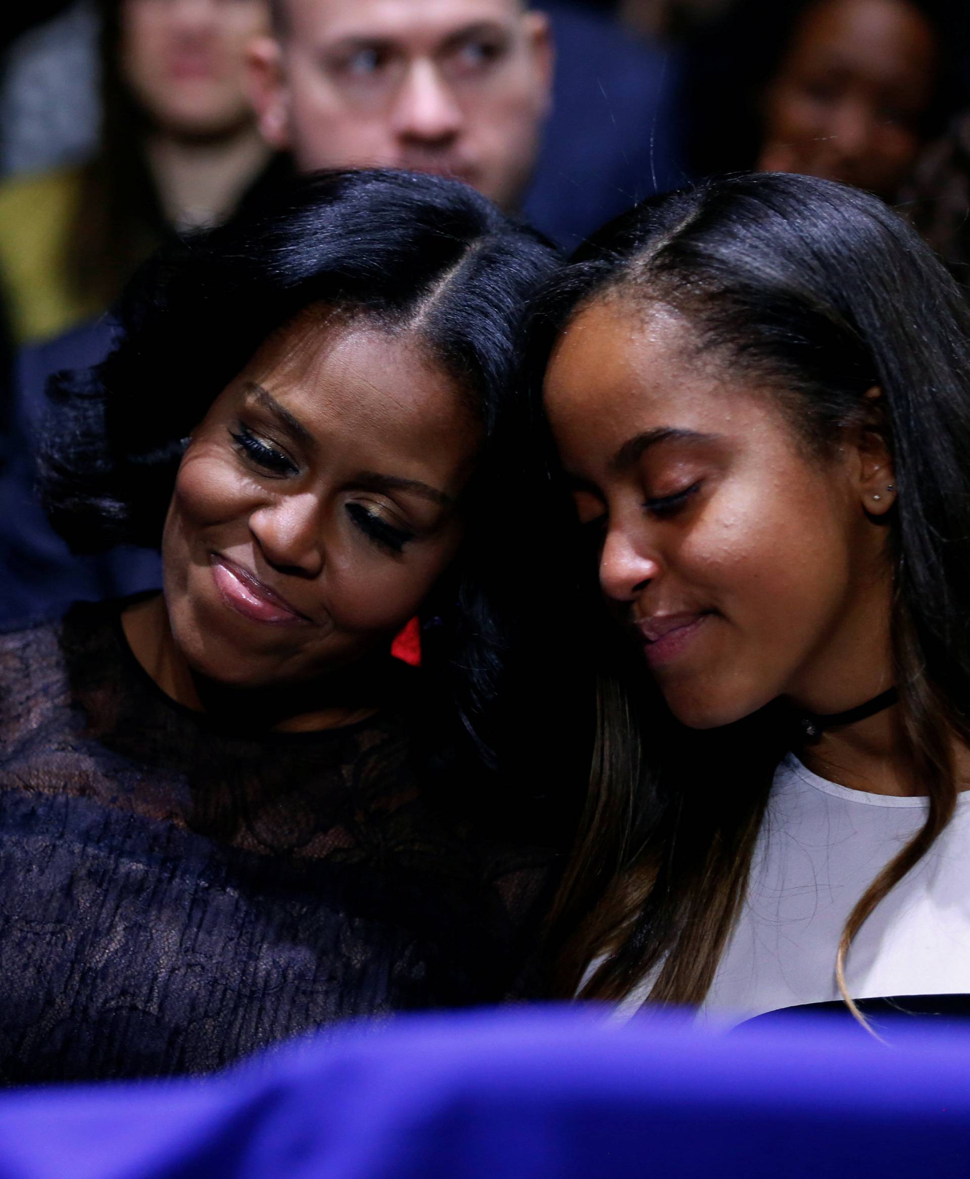 Michelle Obama and her daughter Malia embrace as Obama praises them during his farewell address in Chicago, Illinois