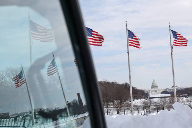 The U.S. Capitol building is framed between U.S. flags after a winter storm swept across a large swatch of the U.S., in Washington