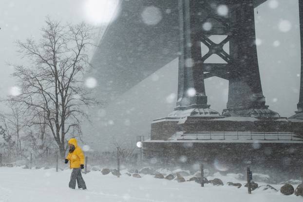 FILE PHOTO: A person walks amid a major winter storm spreading across a large swath of the United States, in Brooklyn