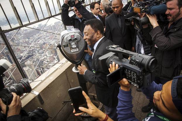 FILE PHOTO: Pele laughs with photographers as he looks out on city on top of Empire State Building during an event to celebrate the start of the New York Cosmos season, in New York