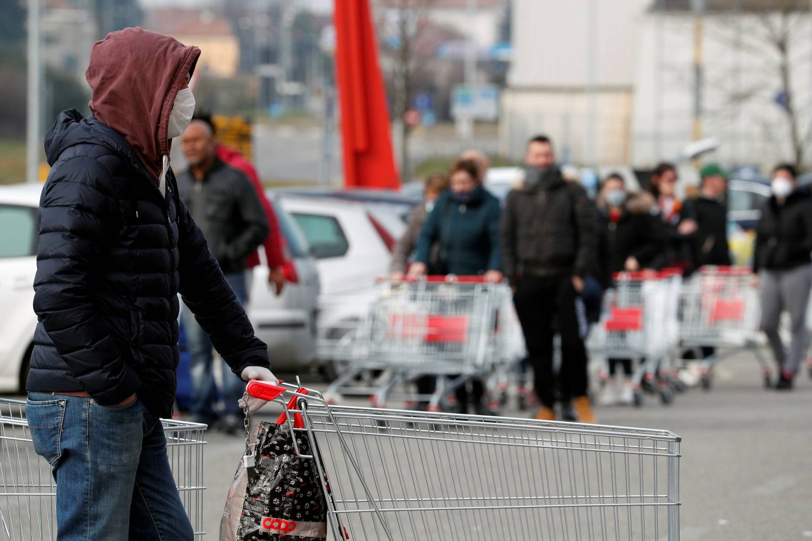 People queue at a supermarket outside the town of Casalpusterlengo