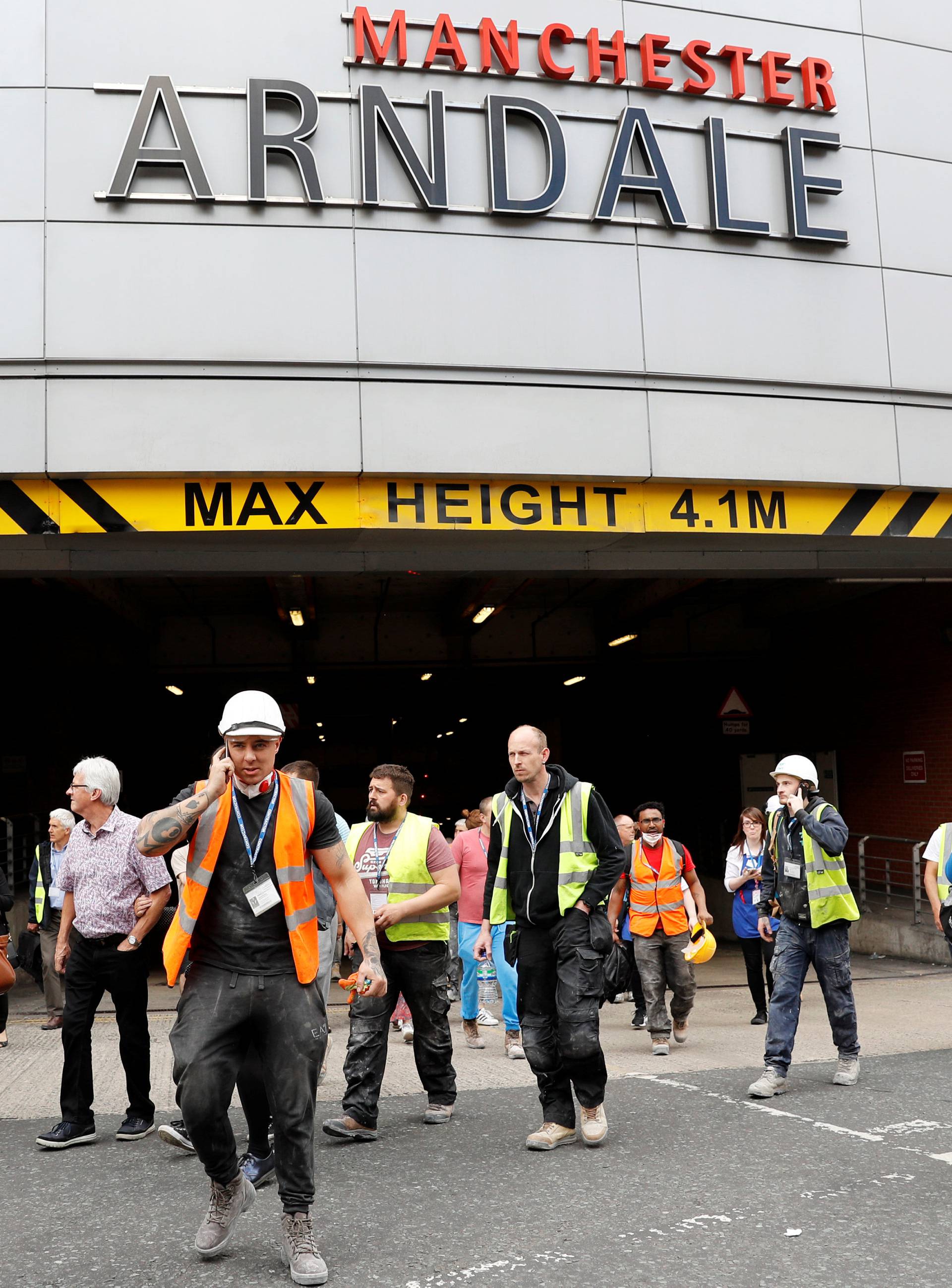 People rush out of the Arndale shopping centre as it is evacuated in Manchester