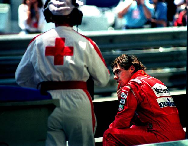 FILE PHOTO: Senna of Brazil is approached by a medic as he sits on the guard rail after crashing in the final practice session for the Monaco Grand Prix