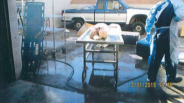 Officials wheel away a stretcher containing a human torso found being thawed with a hose at a facility rented by Southern Nevada Donor Services in Las Vegas, Nevada, U.S. in this handout photo