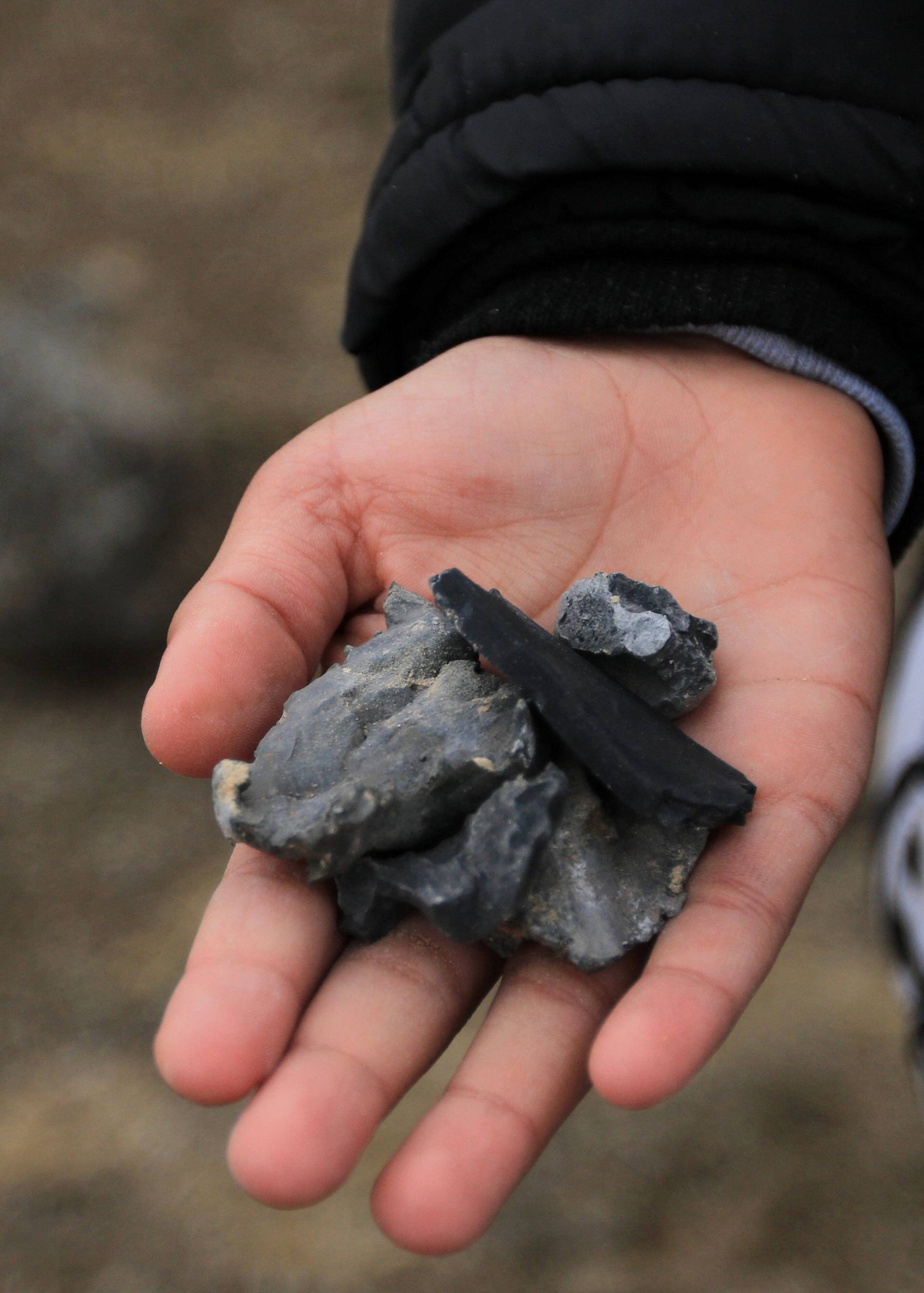 A man holds shrapnel from a missile launched by Iran on U.S.-led coalition forces on the outskirts of Duhok