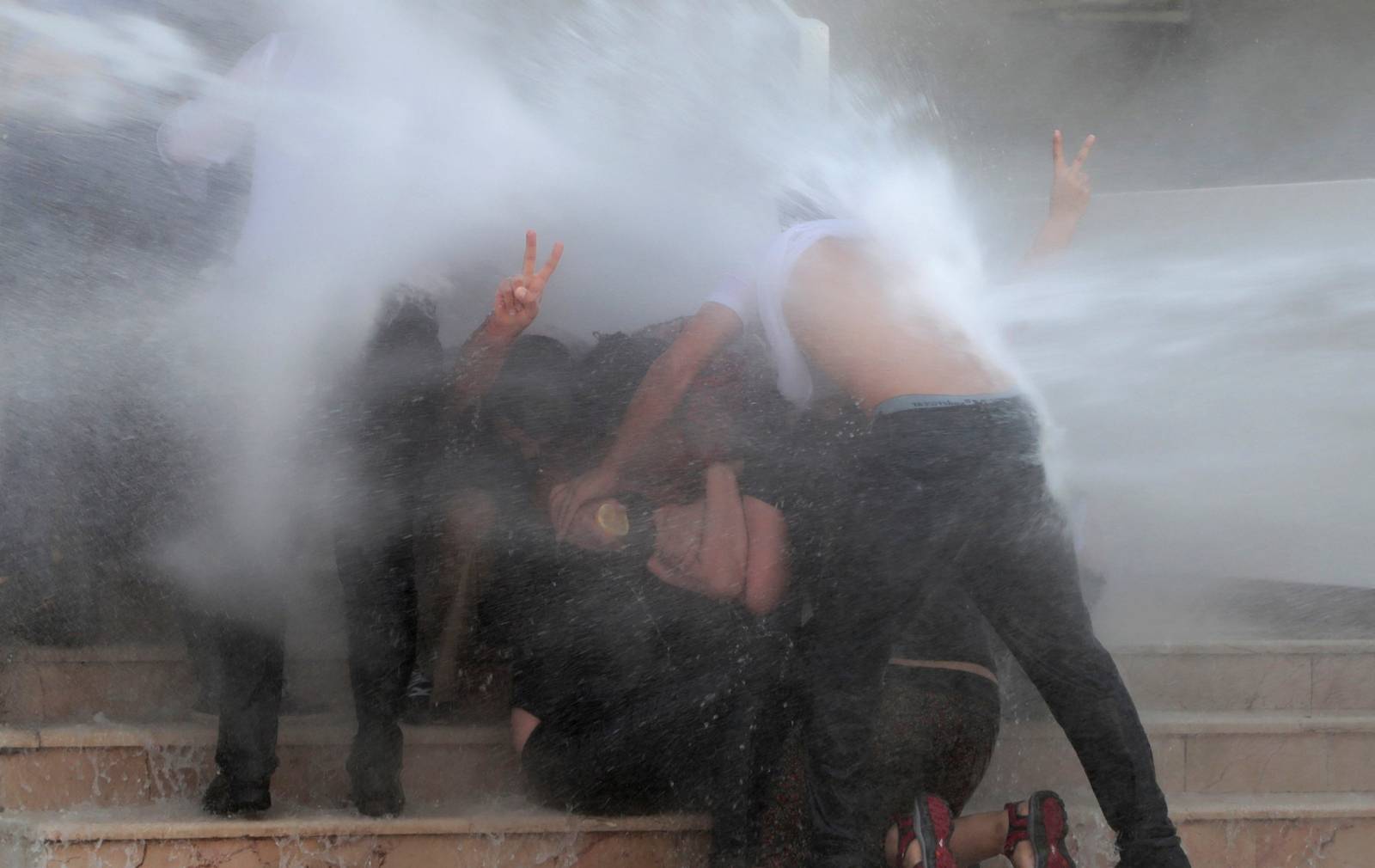 Police use a water cannon to disperse demonstrators during a protest against the replacement of Kurdish mayors with state officials in three cities, in Diyarbakir
