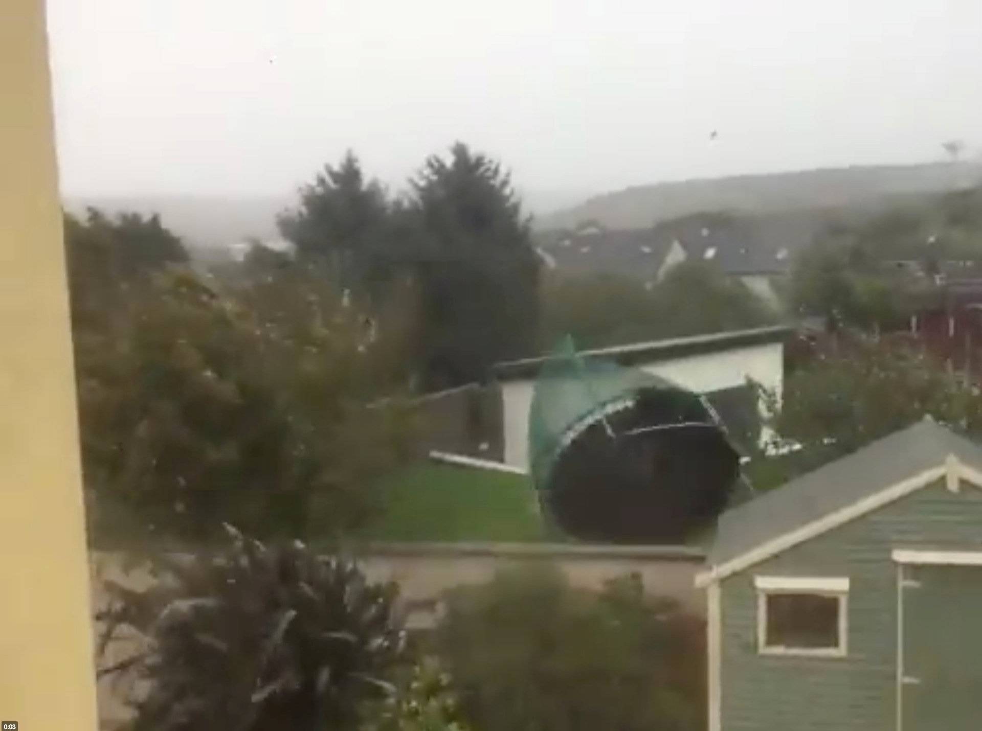 A loose trampoline is blown away by strong winds as storm Ophelia approaches in Cork