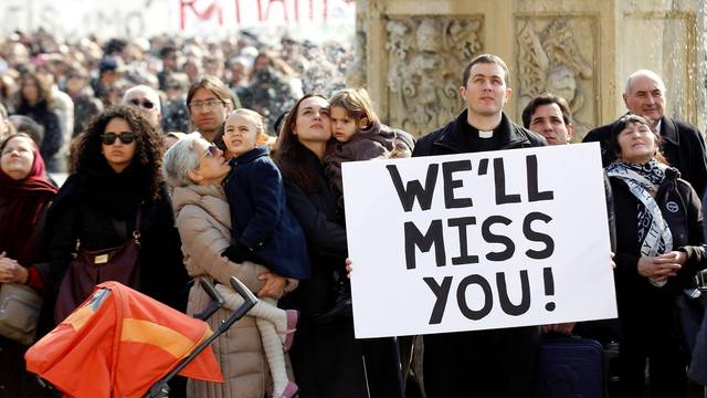 FILE PHOTO: Faithful hold a sign as Pope Benedict XVI leads the Sunday Angelus in Saint Peter's Square at the Vatican