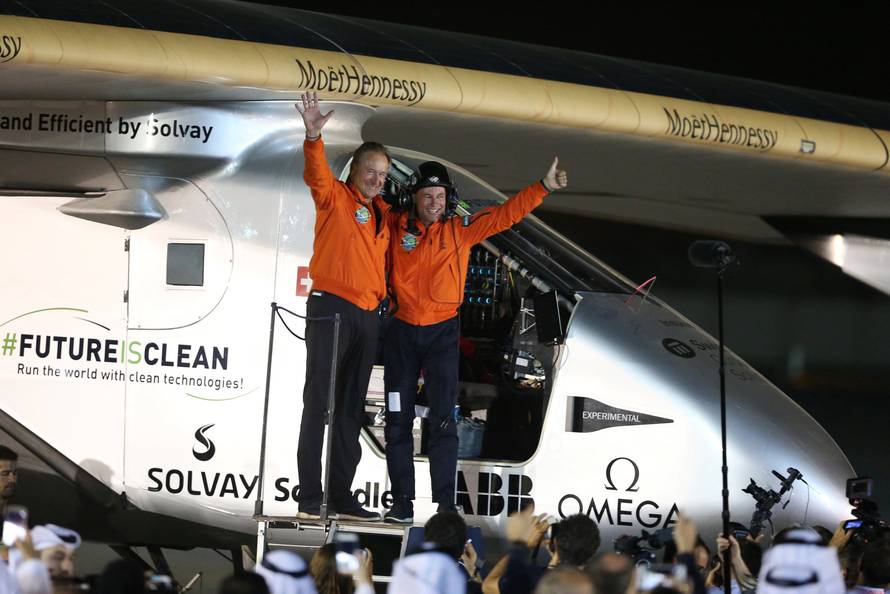 Pilots Andre Borschberg and Bertrand Piccard celebrate their arrival on Solar Impulse 2, a solar powered plane, at an airport in Abu Dhabi, UAE