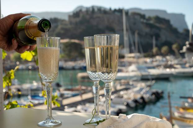 Pouring in three glasses of French champagne sparkling wine and 