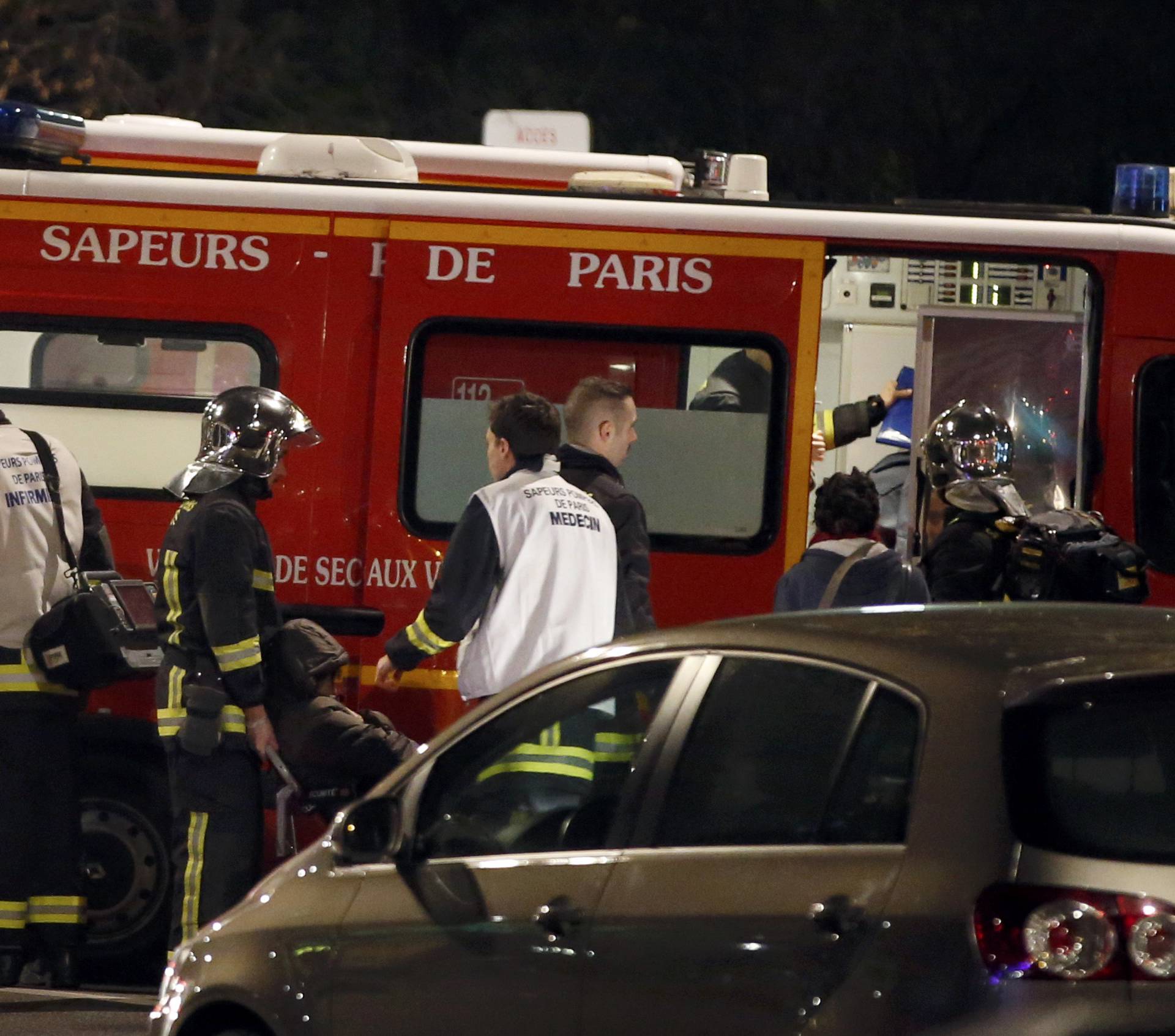  French firemen and doctors tend to a person who was one of six people in a travel agency when an armed man entered in what appears to be a robbery, according to a police source, in Paris