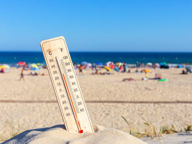 Thermometer for the temperature on the beach, in the summer in the heat. Global warming.