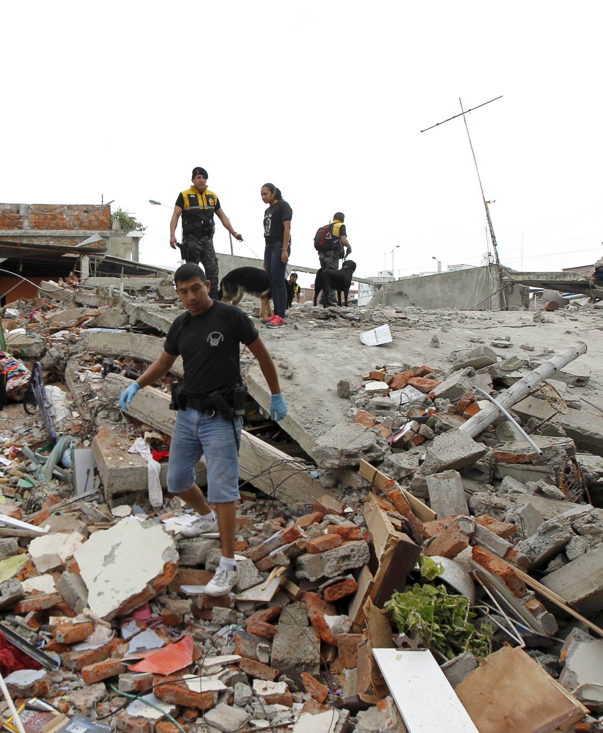Red Cross members, military and police officers work at a collapsed area after an earthquake struck off the Pacific coast, at Tarqui neighborhood in Manta