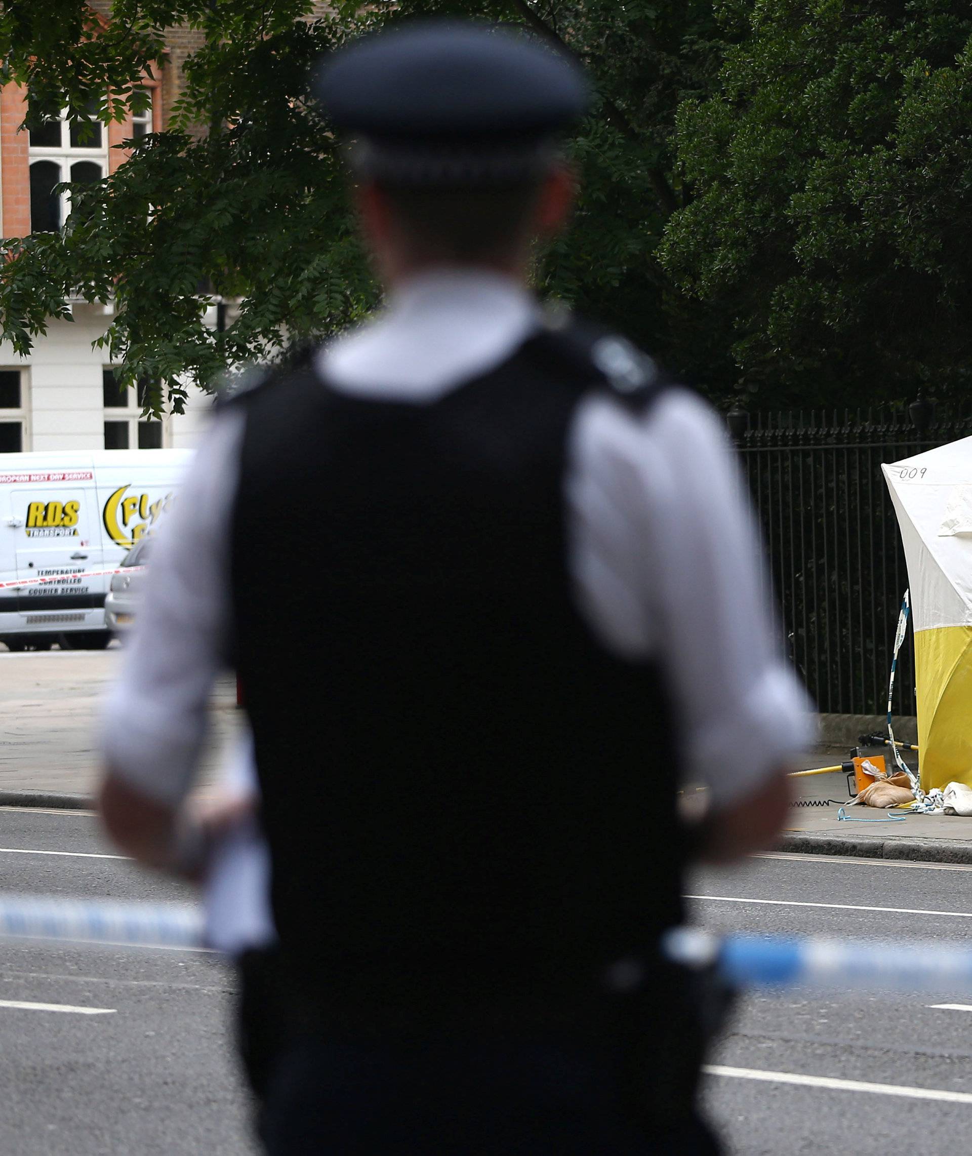 A police officer stands near a forensics tent after a knife attack in Russell Square in London