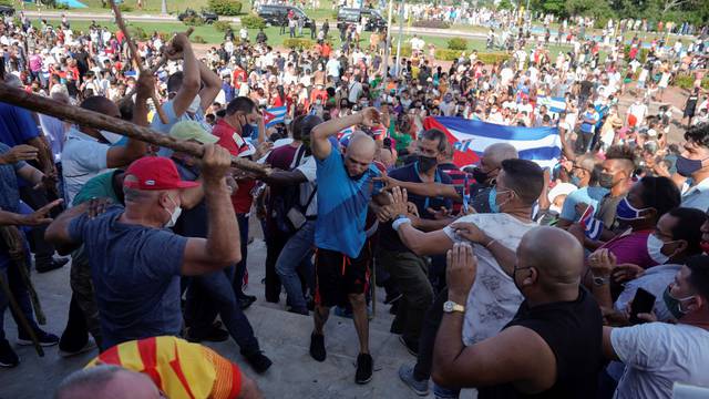 People clash with plain clothes police during protests against and in support of the government, in Havana