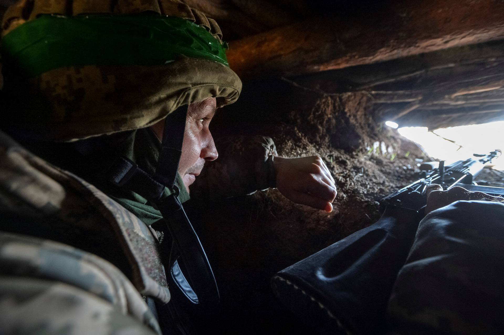 A Ukrainian service member is seen in a trench at a position on a front line near the city of Bakhmut