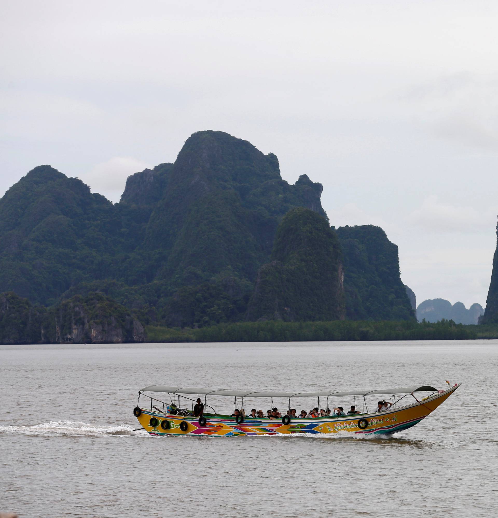 A tourist boat travels near Kho Panyee village, Phang Nga Province, Thailand,