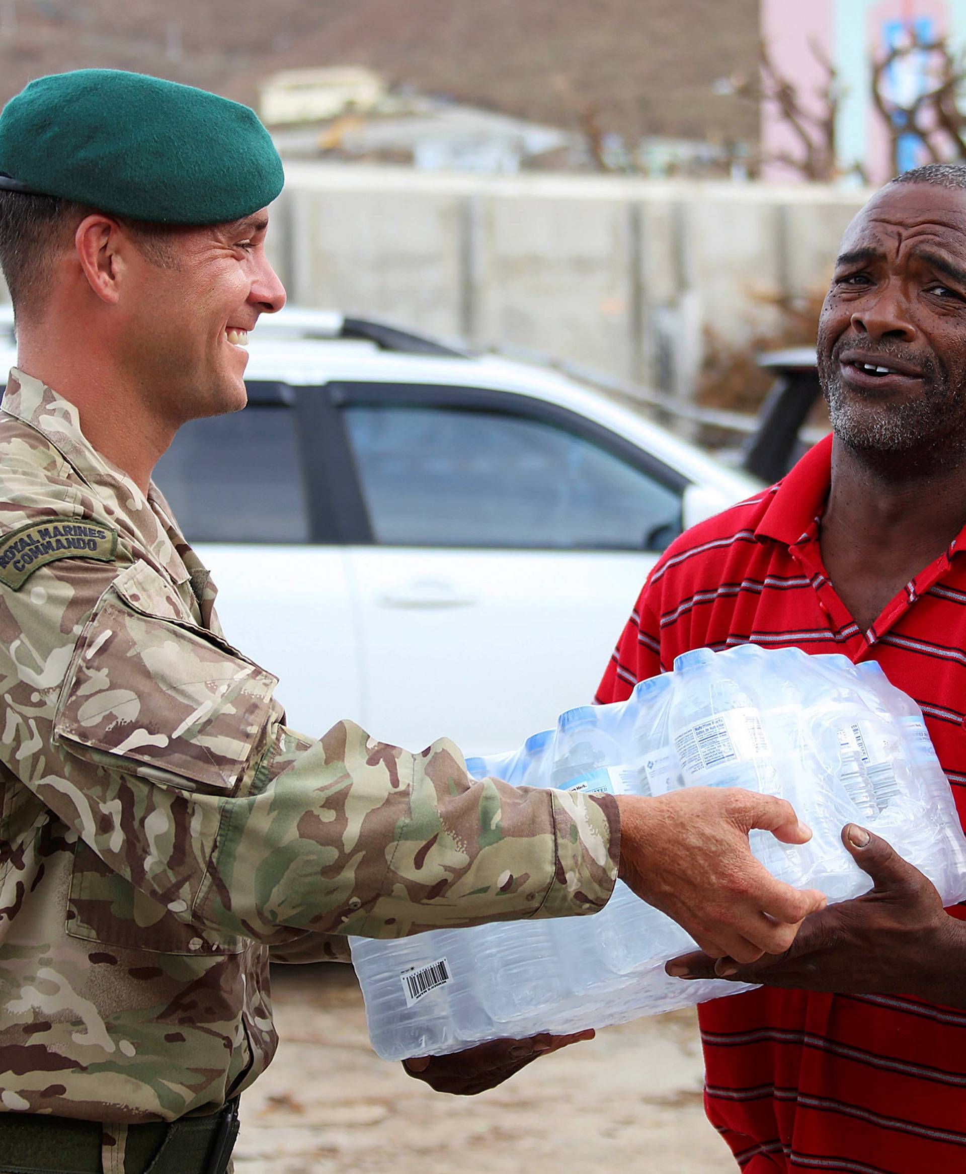 A Royal Marine Commando hands out aid in Tortola in the British Virgin Islands
