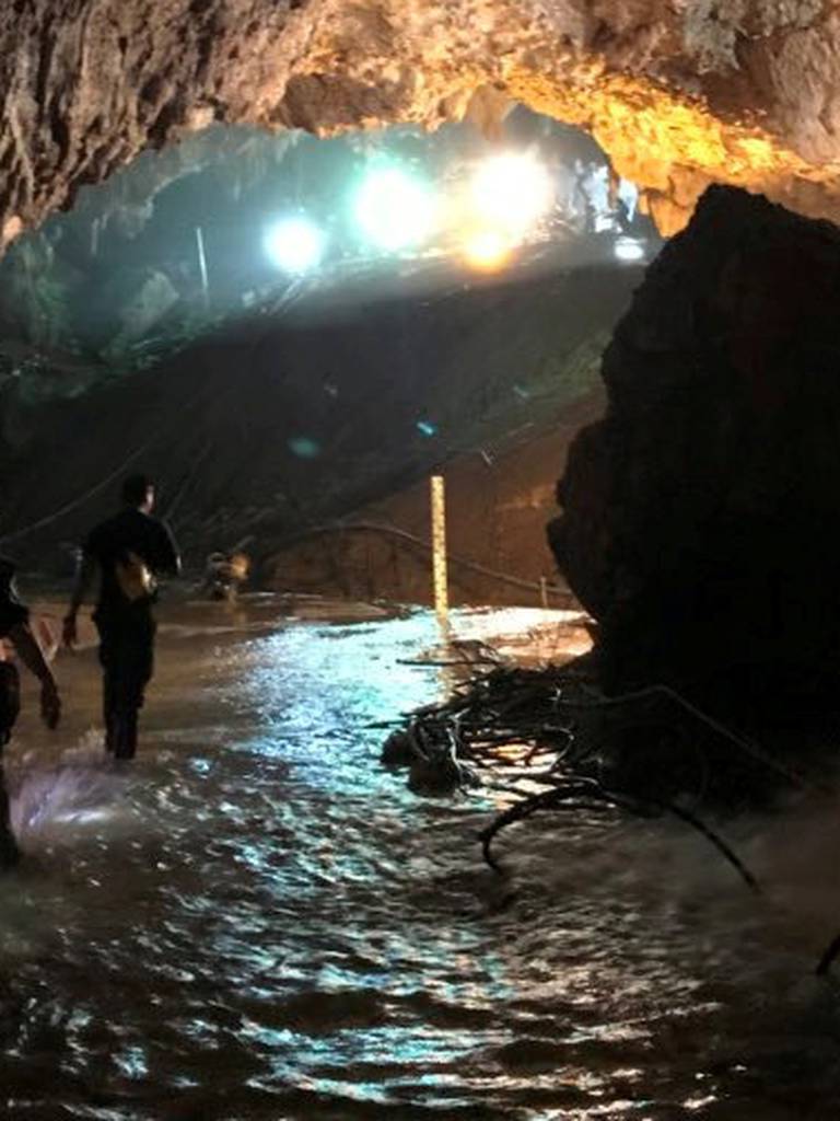 Rescue personnel walk in a cave at the Tham Luang cave complex during a mission to evacuate the remaining members of a soccer team trapped inside, in Chiang Rai