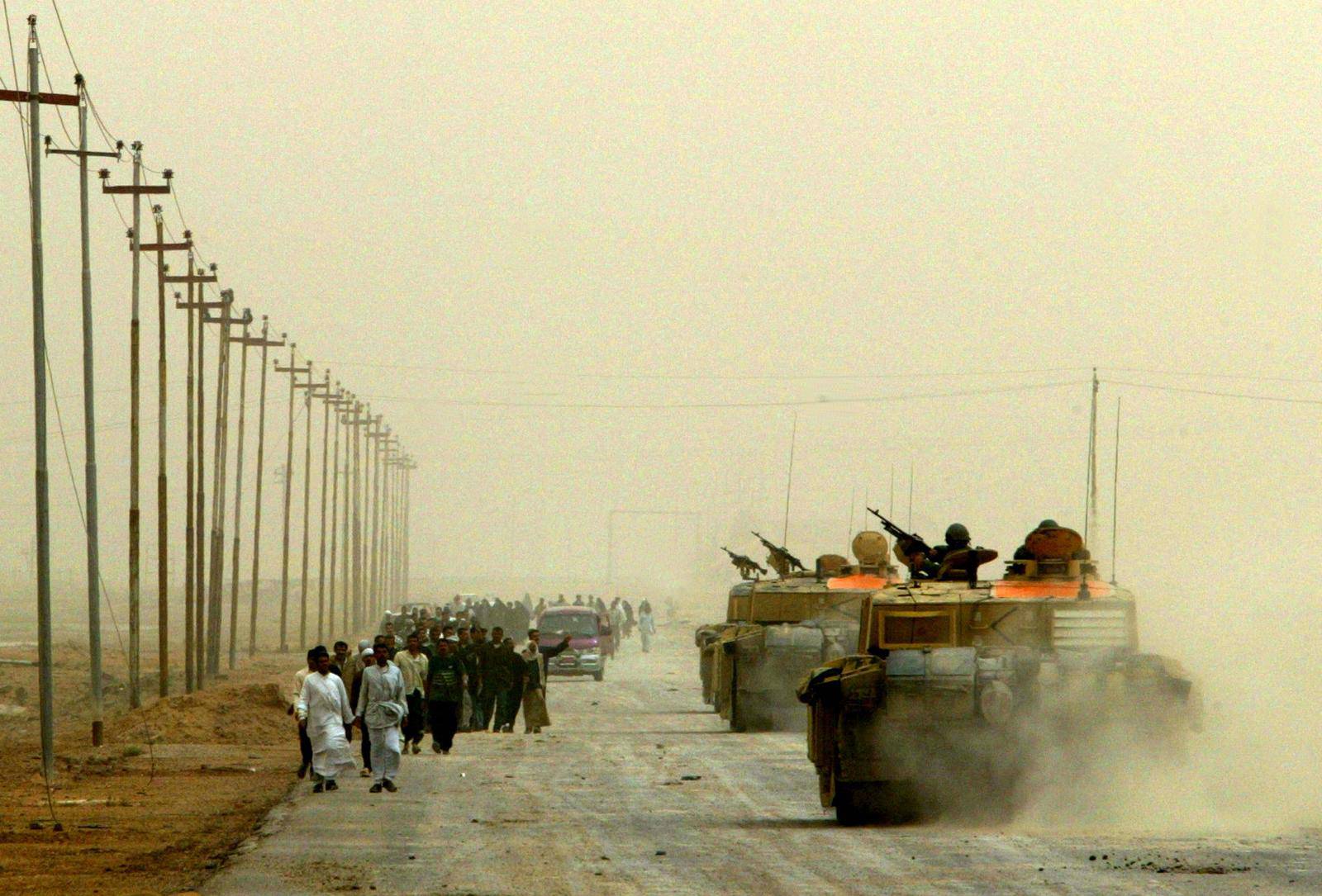 FILE PHOTO: Residents of Basra leave city past British army tanks