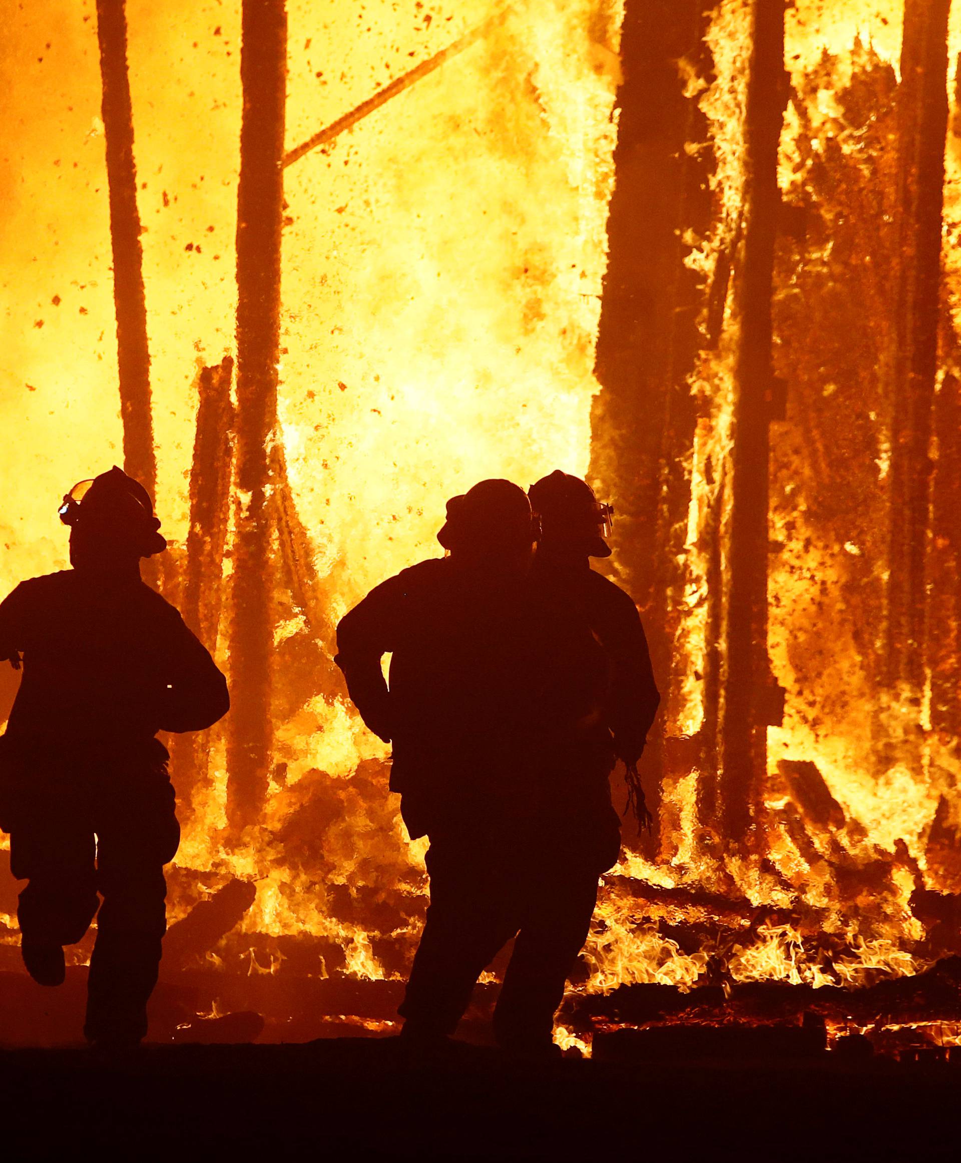 Firefighters flee collapsing structure after a Burning Man participant runs into the flames of the "Man Burn" at the Burning Man arts and music festival in the Black Rock Desert of Nevada