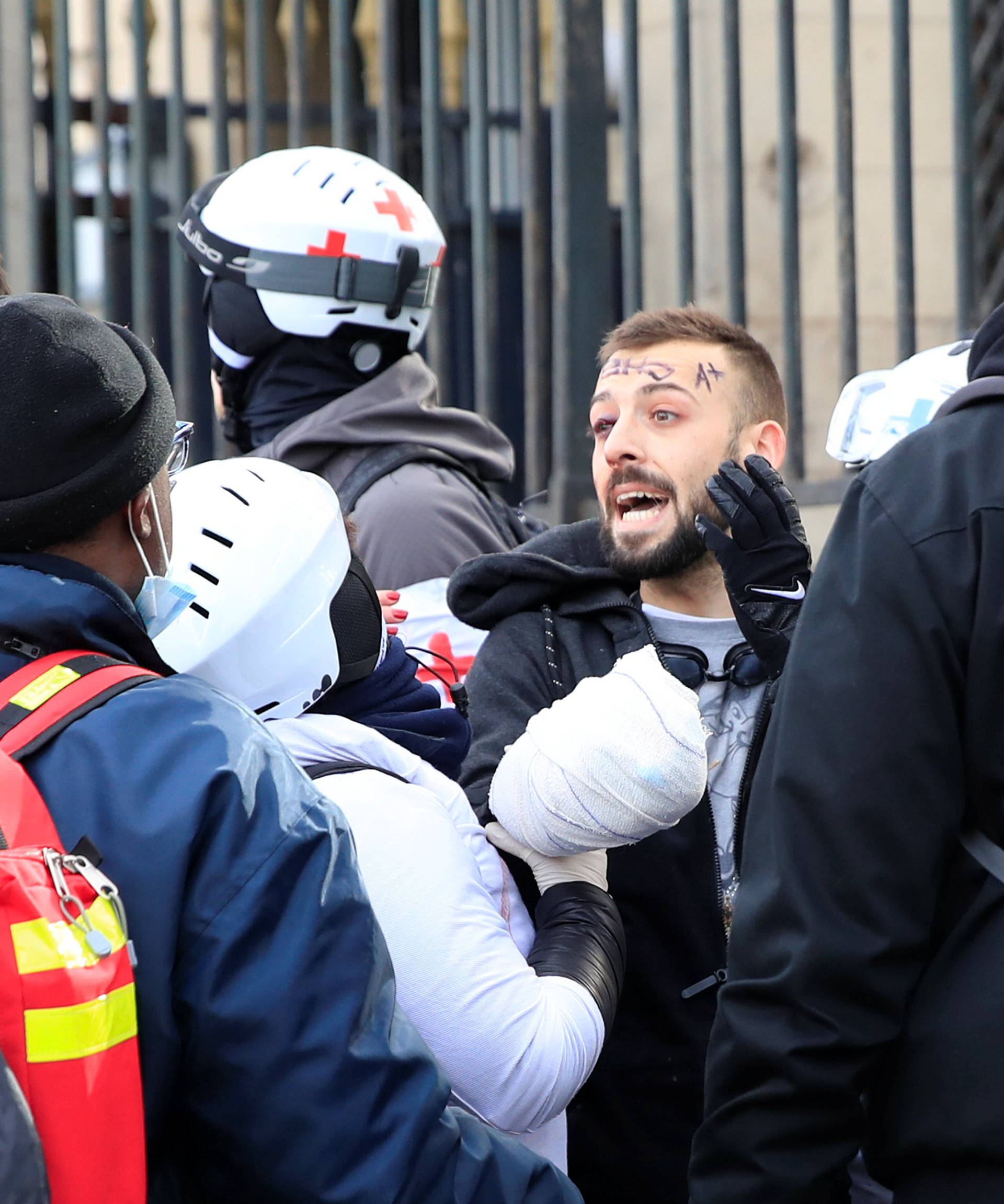 An injured protester is given help during a demonstration by the "yellow vests" movement in Paris