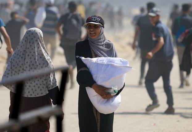 Palestinians gather to receive aid supplies amid a hunger crisis, in Beit Lahia
