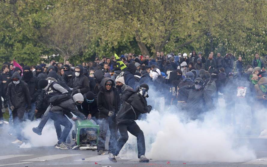 Masked youths face off with French police during a demonstration against the French labour law proposal in Paris
