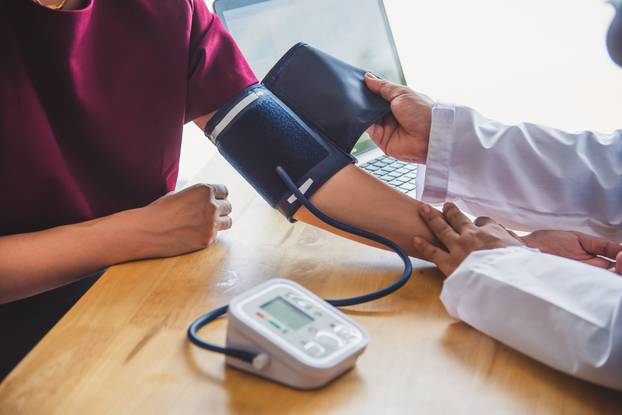 doctor measuring blood pressure from her patient