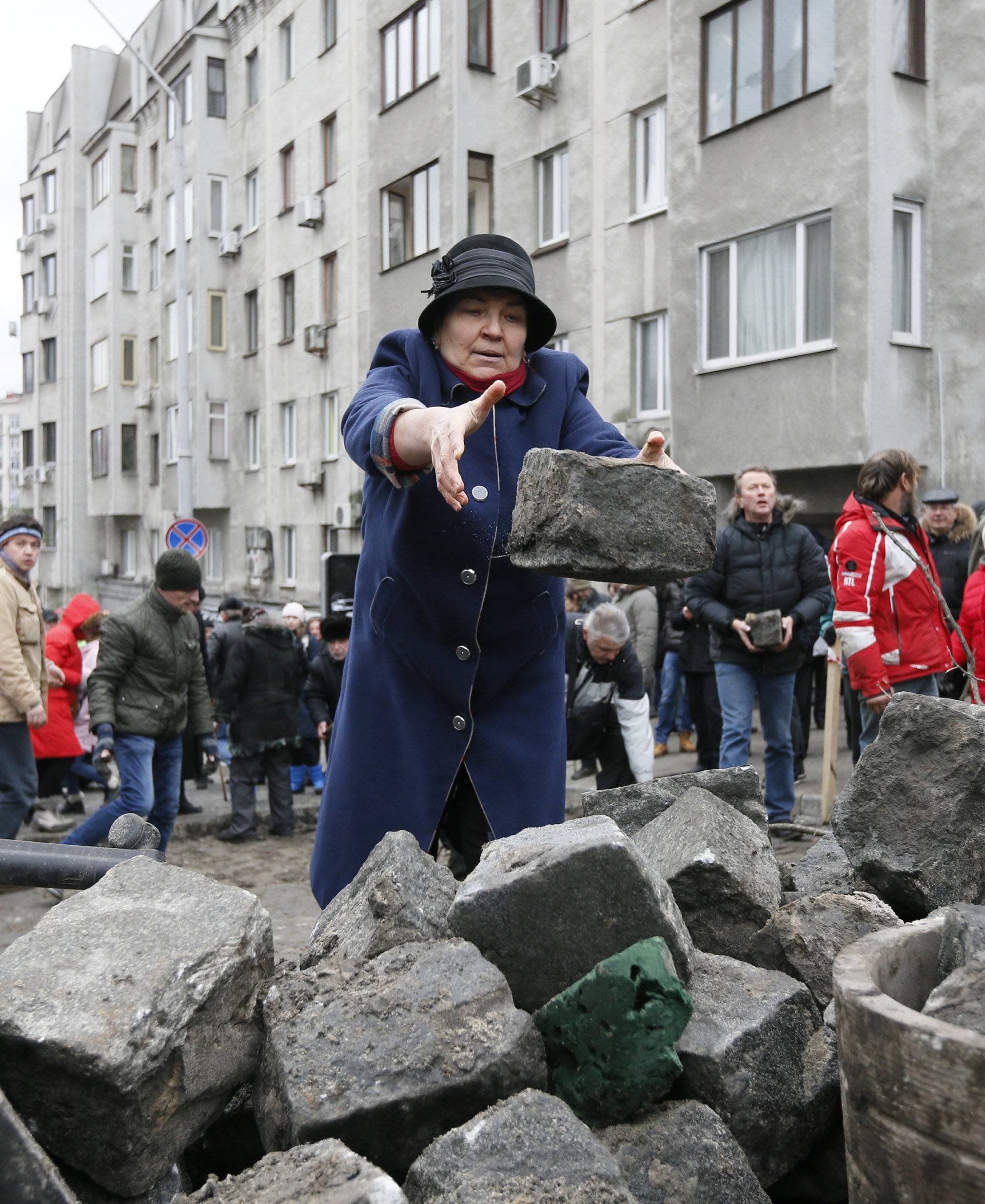 Supporters of Georgian former President Mikheil Saakashvili move paving stones during clashes with police in Kiev