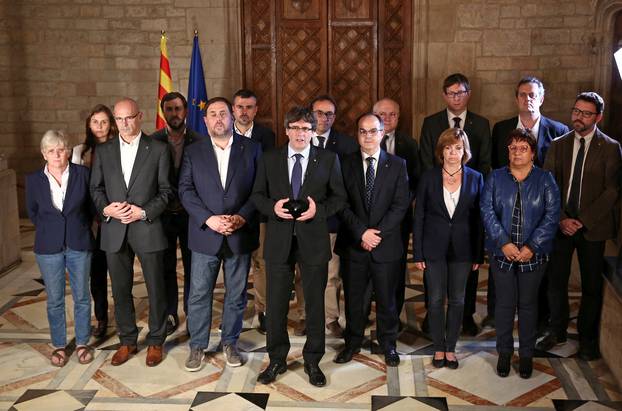 Catalan Regional President Puigdemont is flanked by members of his government as he makes a statement at Generalitat Palace in Barcelona