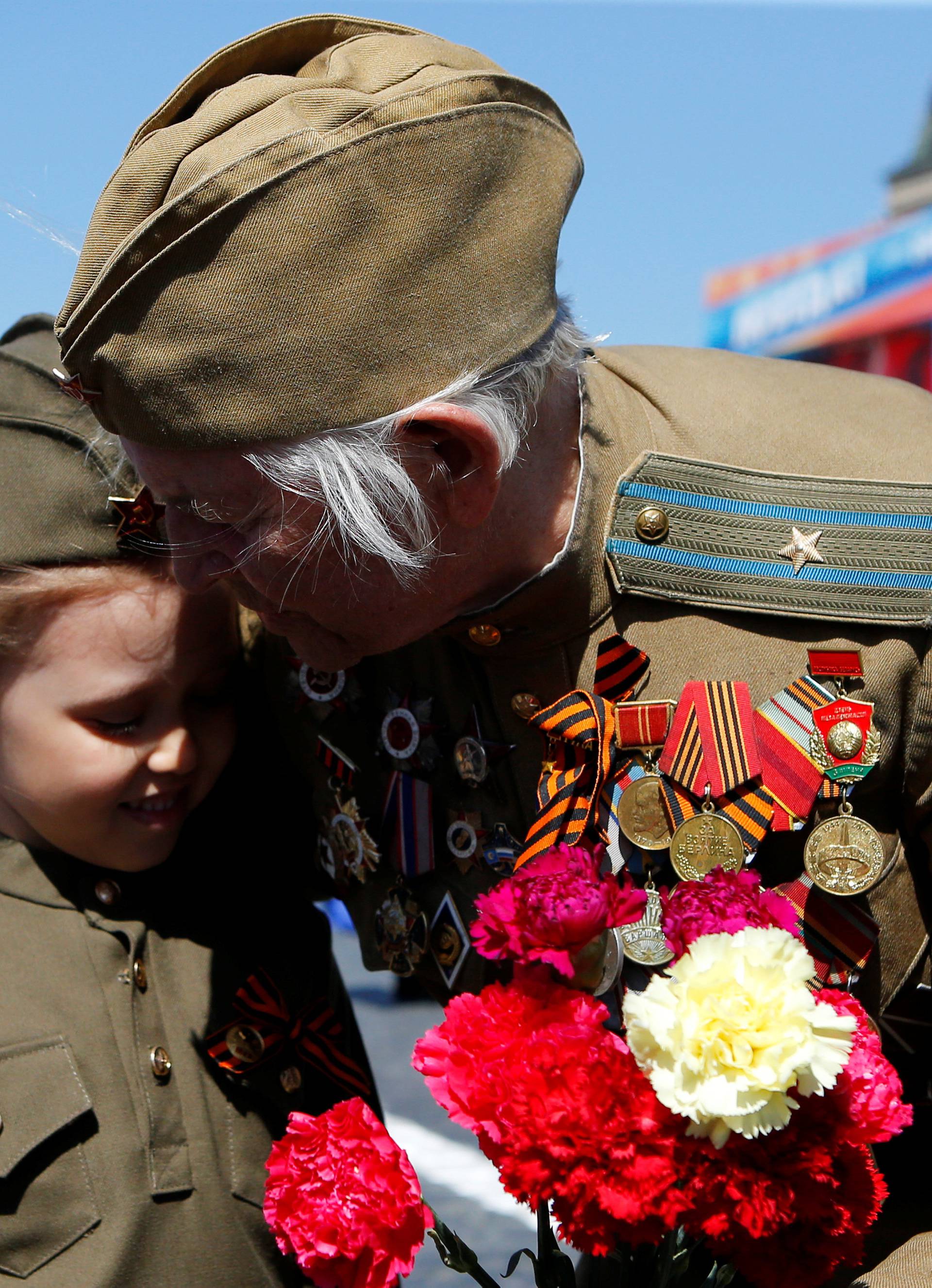 A veteran embraces a girl during the Victory Day celebrations, marking the 73rd anniversary of the victory over Nazi Germany in World War Two, at Red Square in Moscow