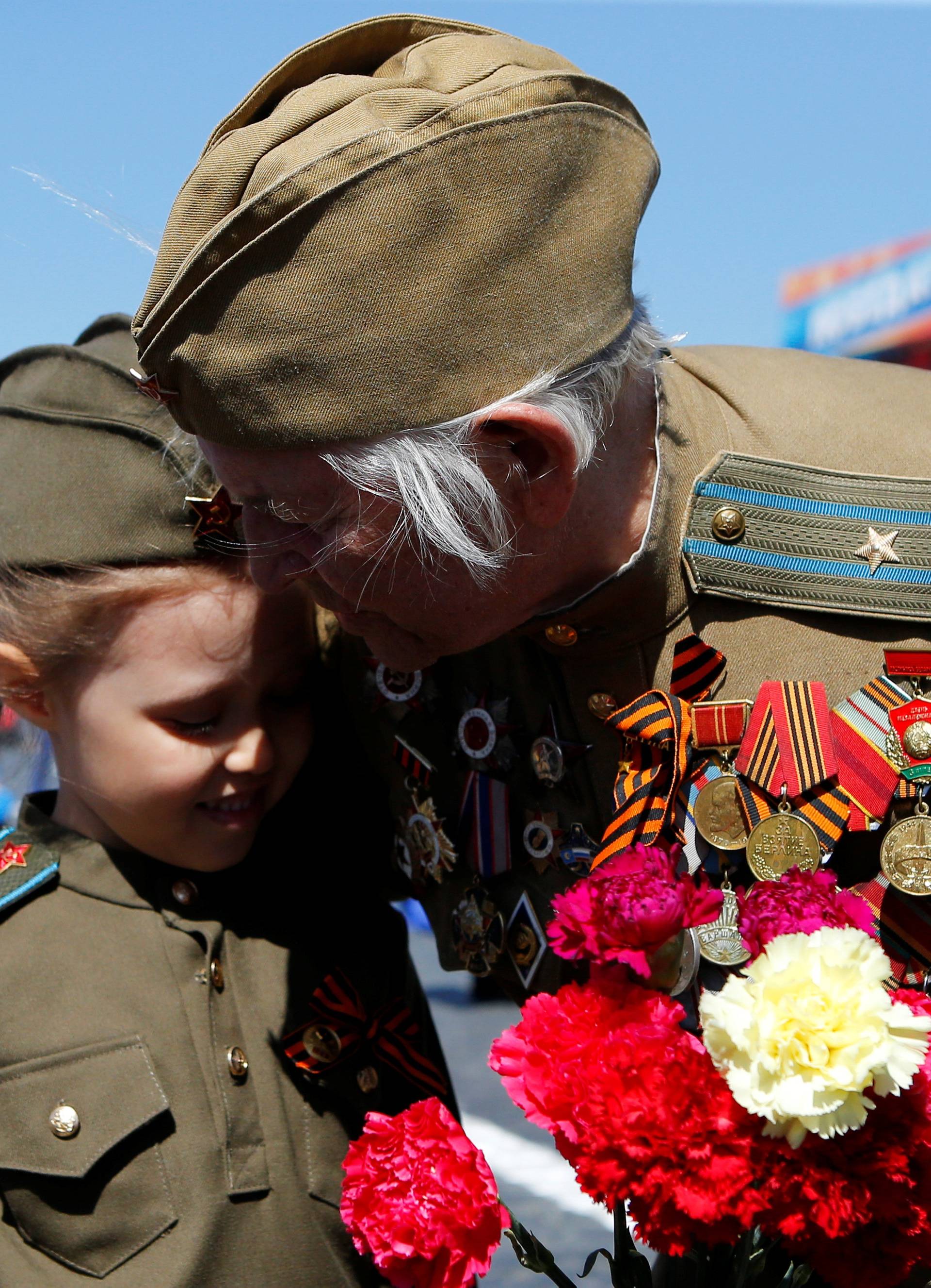 A veteran embraces a girl during the Victory Day celebrations, marking the 73rd anniversary of the victory over Nazi Germany in World War Two, at Red Square in Moscow