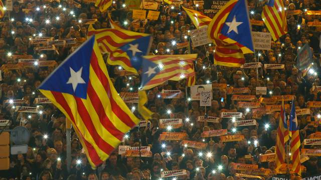 Protesters hold the lights of their mobile phones as they wave Estelada flags during a demonstration called by pro-independence associations asking for the release of jailed Catalan activists and leaders, in Barcelona