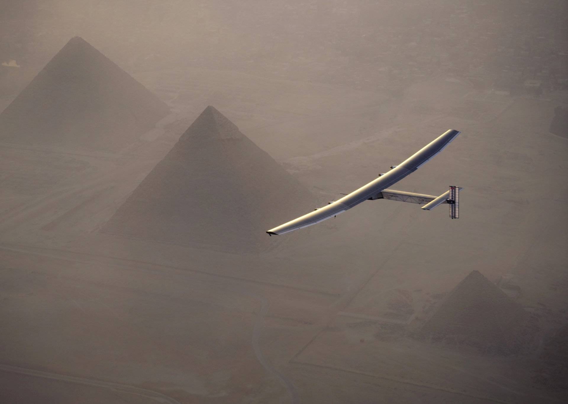 Solar Impulse 2, the solar powered plane, piloted by Swiss pioneer Andre Borschberg is seen during the flyover of the pyramids of Giza on July 13, 2016 prior to the landing in Cairo