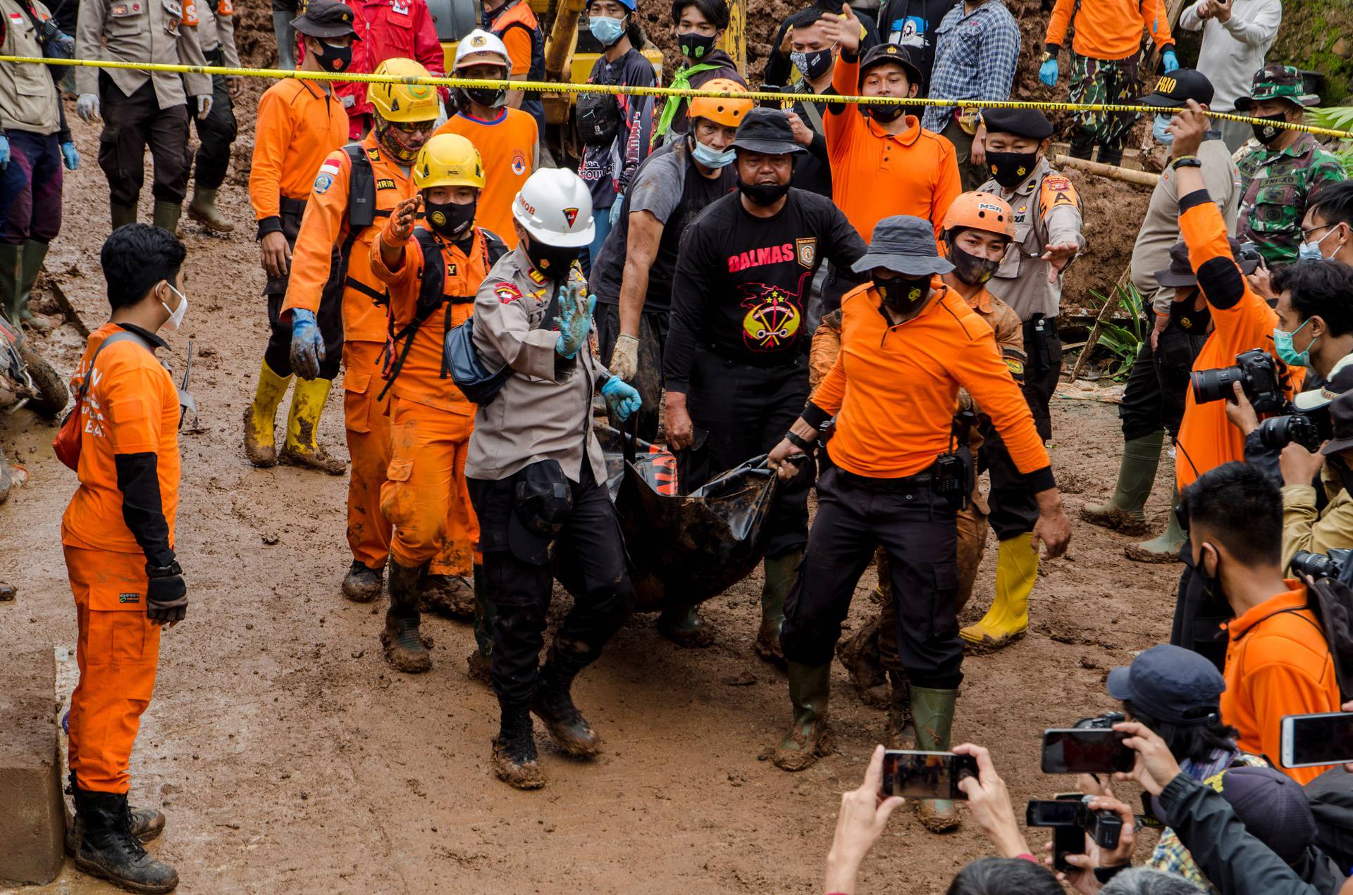 Indonesian rescuers carry a body bag during the search for victims buried by landslides in Sumedang