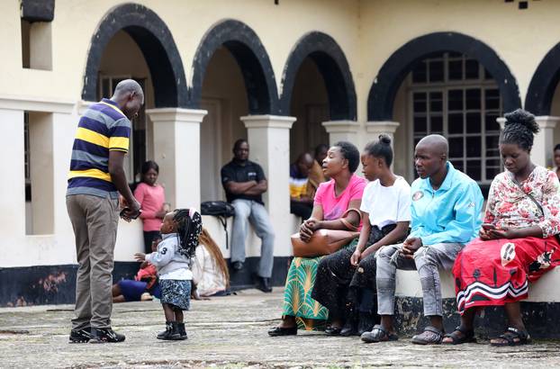 Vesela djevojčica sa slatkom frizurom  ispred suda u Zambiji 