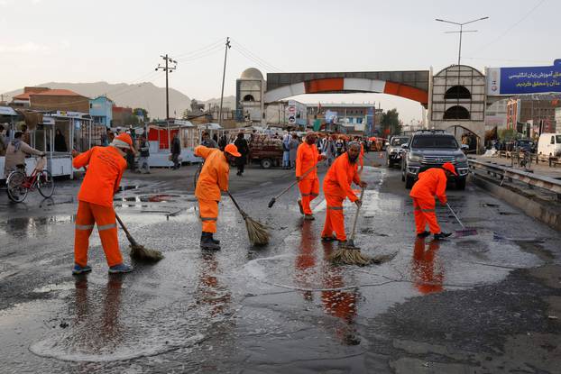 Municipality workers clean the blast site in Kabul